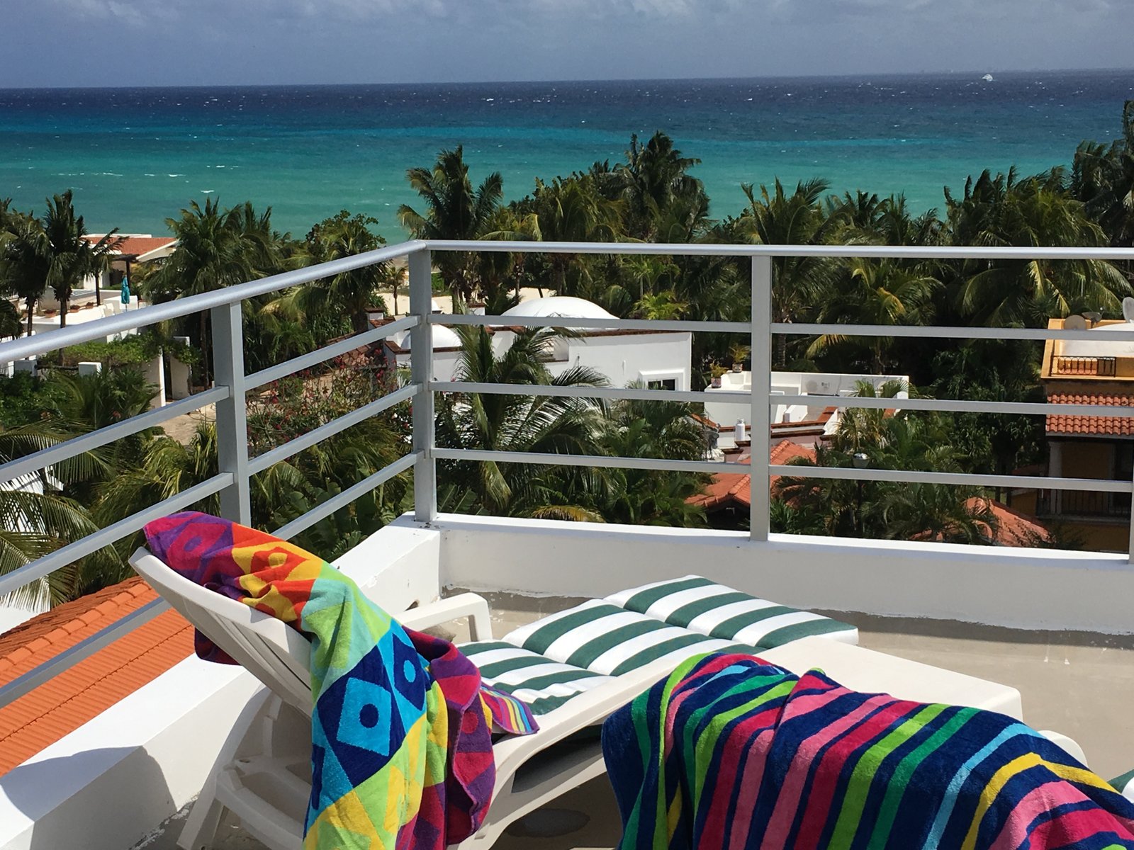 Casa Alma solarium, colorful towels and Caribbean Sea